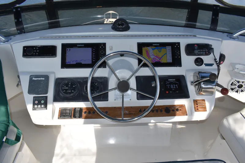  Yacht Photos Pics Control panel of a 2001 Mainship 390 boat with navigation equipment and steering wheel.