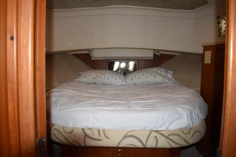  Yacht Photos Pics Cozy bedroom in 2001 Mainship 390 yacht with plush bedding and wooden accents.