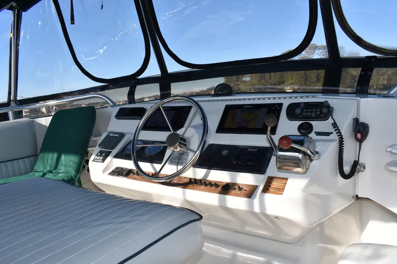  Yacht Photos Pics 2001 Mainship 390 helm with steering wheel, navigation controls, and comfortable seating.