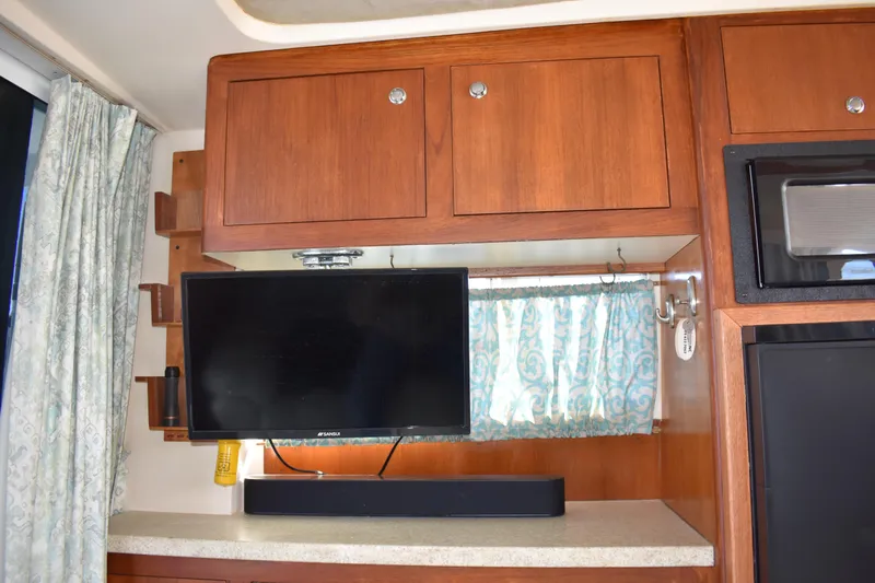  Yacht Photos Pics Interior of 2001 Mainship 390 with mounted TV and wooden cabinetry.