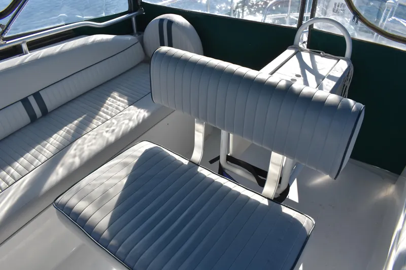  Yacht Photos Pics 2001 Mainship 390 boat interior with white cushioned seating and table.