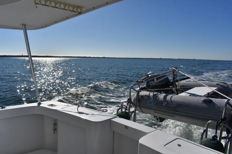  Yacht Photos Pics 2001 Mainship 390 cruising on sunny waters with inflatable boat in tow.