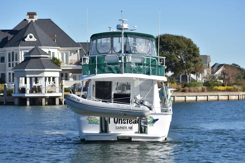  Yacht Photos Pics 2001 Mainship 390 yacht cruising near waterfront homes.