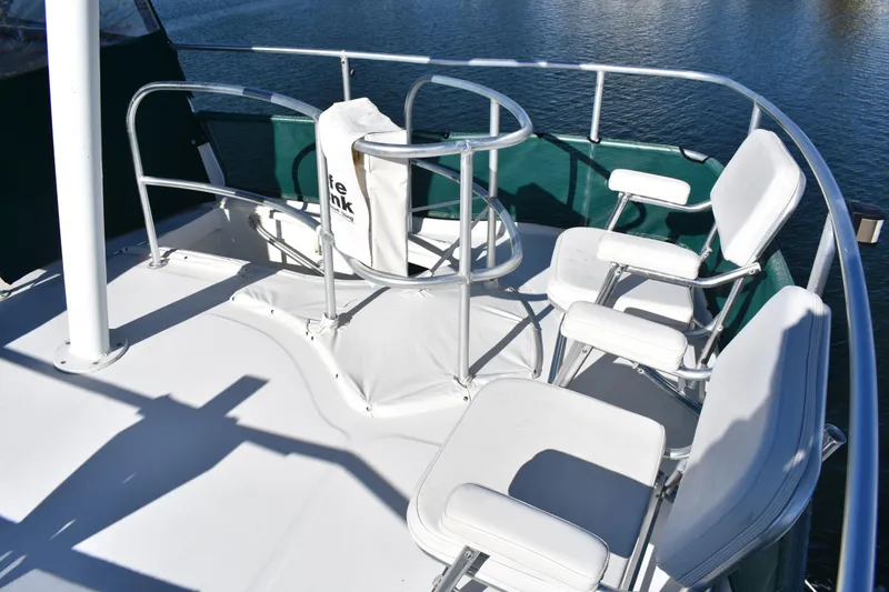  Yacht Photos Pics Flybridge seating area on a 2001 Mainship 390 yacht, featuring white cushioned chairs.