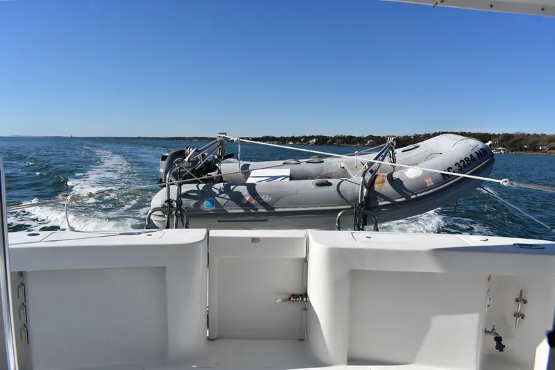  Yacht Photos Pics 2001 Mainship 390 yacht towing an inflatable boat on a sunny day.
