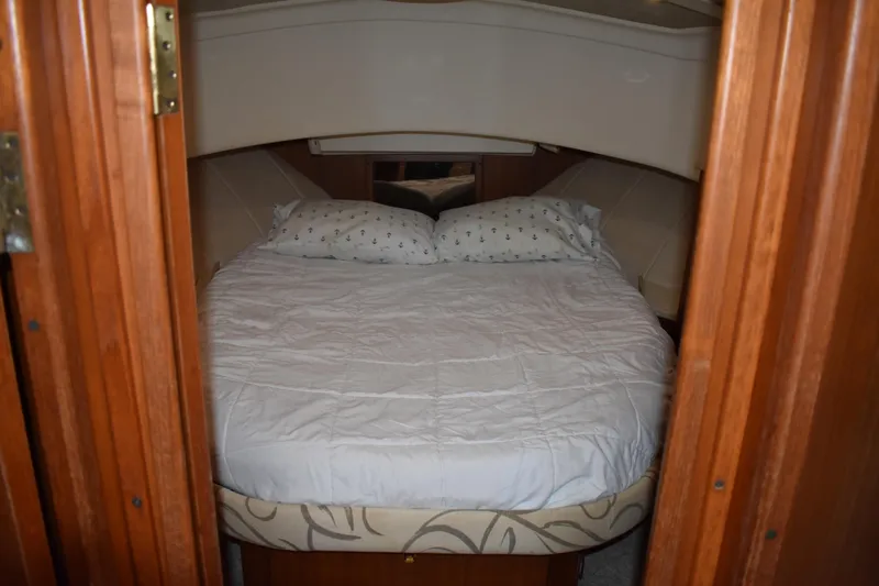  Yacht Photos Pics Cozy bedroom in 2001 Mainship 390 yacht with wooden accents and comfortable bedding.