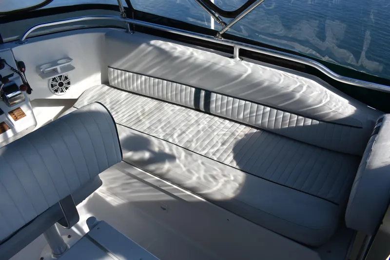  Yacht Photos Pics 2001 Mainship 390 boat interior with white cushioned seating and control panel.