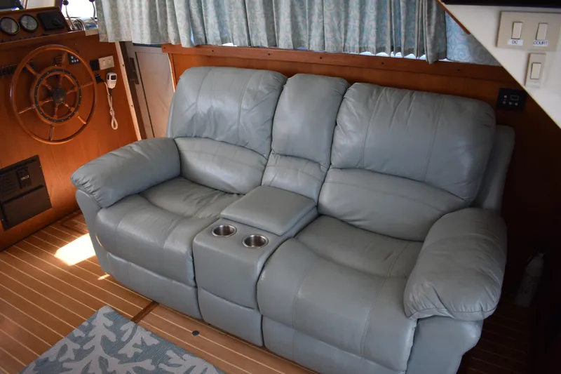  Yacht Photos Pics Interior of 2001 Mainship 390 with leather sofa and wooden helm.