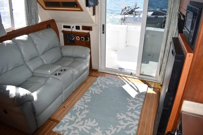  Yacht Photos Pics Interior of 2001 Mainship 390 yacht with leather sofa and ocean view through glass door.