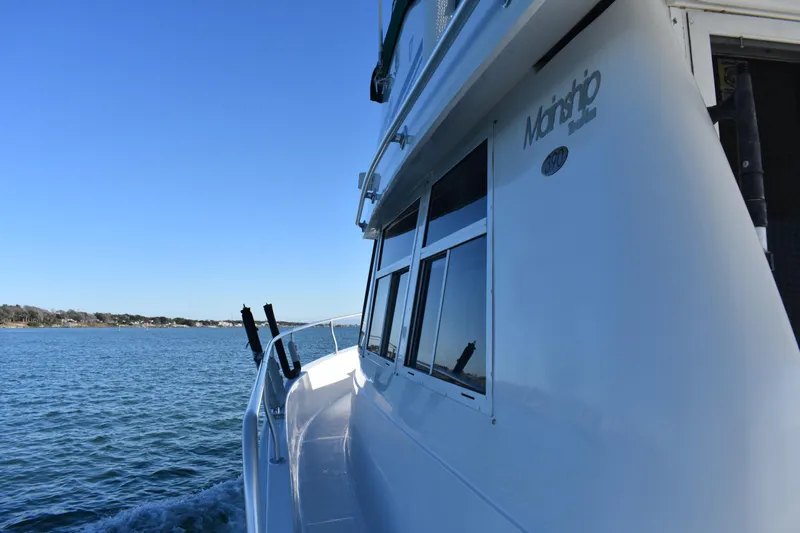  Yacht Photos Pics 2001 Mainship 390 boat cruising on a calm blue sea under a clear sky.