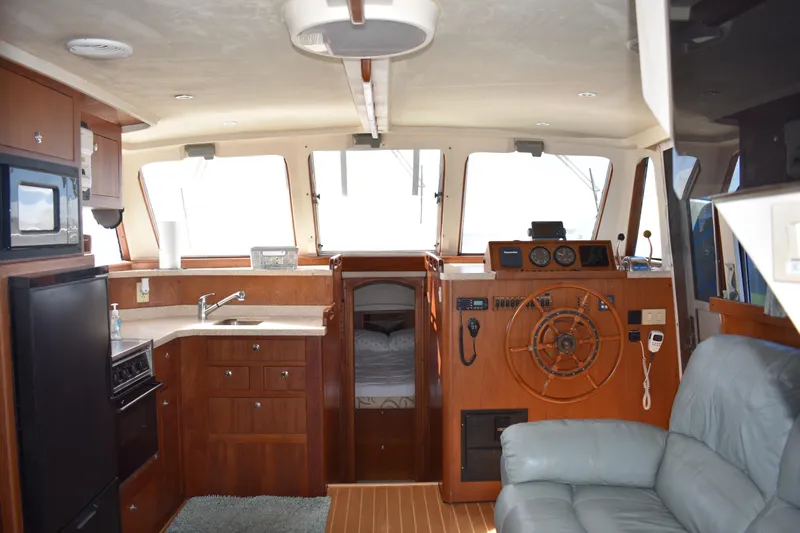  Yacht Photos Pics Interior of 2001 Mainship 390 yacht with kitchen, steering wheel, and seating area.