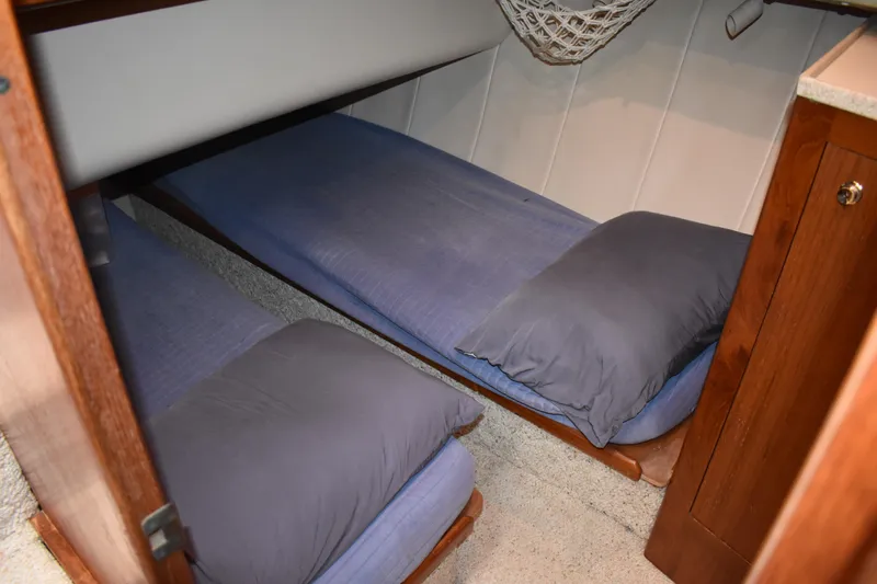  Yacht Photos Pics Cozy twin beds in 2001 Mainship 390 cabin with blue bedding and wooden accents.