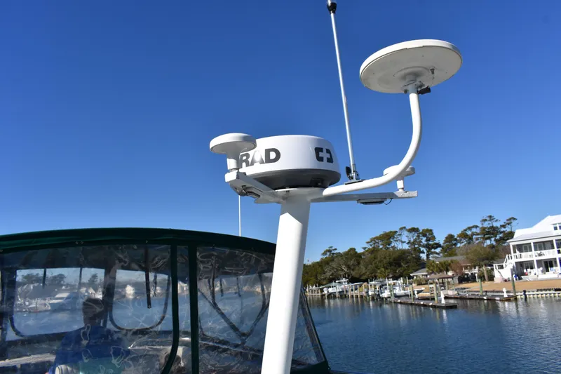  Yacht Photos Pics Radar equipment on a 2001 Mainship 390 boat, docked near waterfront homes.
