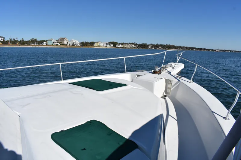  Yacht Photos Pics 2001 Mainship 390 yacht deck with ocean view and coastal homes in background.