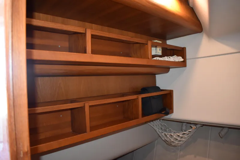  Yacht Photos Pics Wooden shelves in a 2001 Mainship 390 boat interior, featuring storage compartments.
