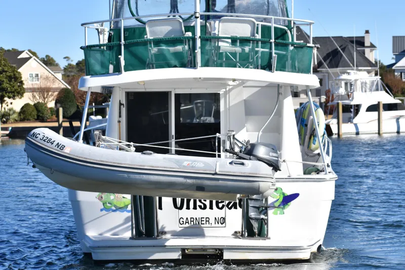  Yacht Photos Pics 2001 Mainship 390 yacht with dinghy, docked in a scenic marina setting.