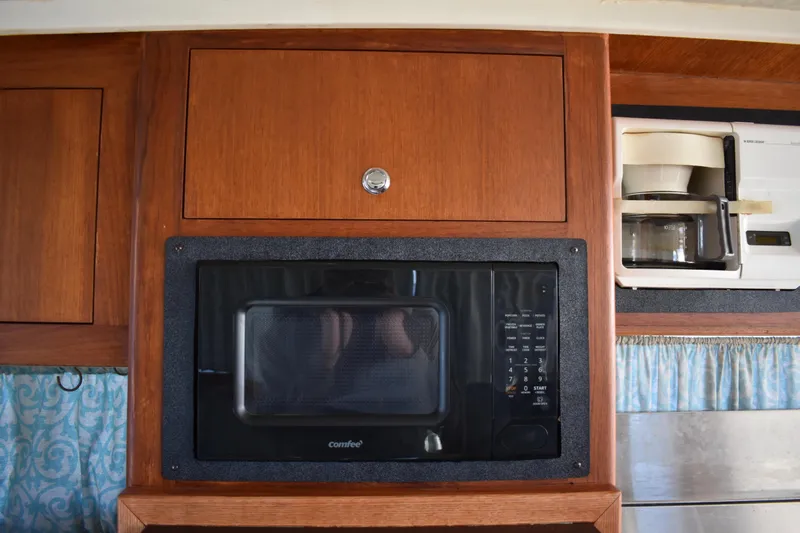  Yacht Photos Pics 2001 Mainship 390 interior with microwave, coffee maker, and wooden cabinetry.