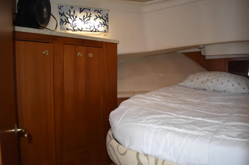  Yacht Photos Pics Cozy cabin interior of 2001 Mainship 390 with bed and wooden cabinetry.