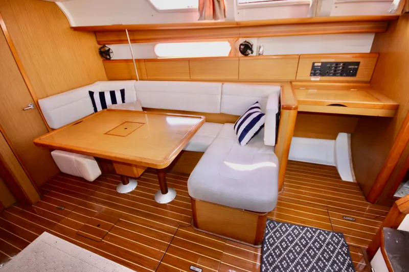 Vela Via Yacht Photos Pics Interior of 2009 Jeanneau 44i sailboat with wooden flooring and cozy seating area.