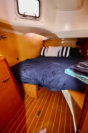 Vela Via Yacht Photos Pics Cozy cabin interior of 2009 Jeanneau 44i sailboat with wooden finish and comfortable bedding.