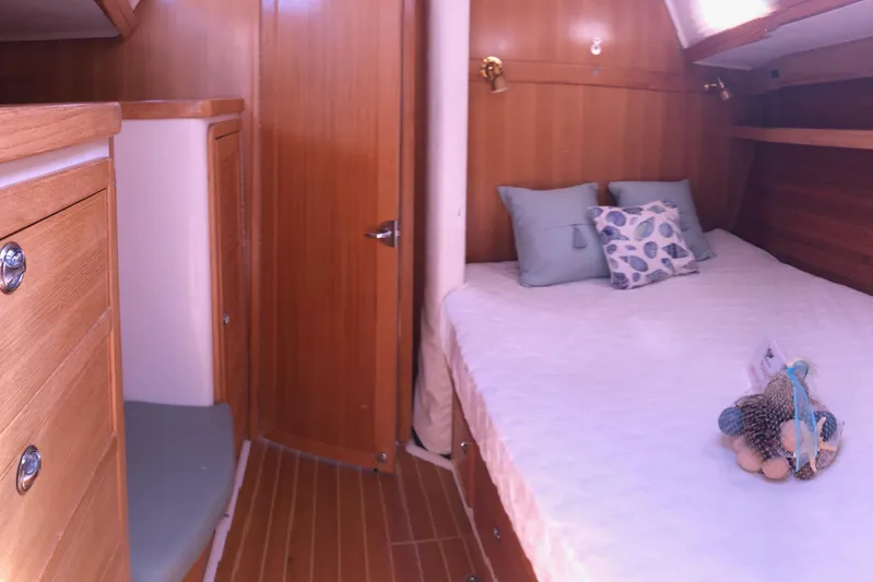 Makani Yacht Photos Pics Cozy cabin interior of 2008 Catalina 42 MkII sailboat with wooden finish and comfortable bedding.