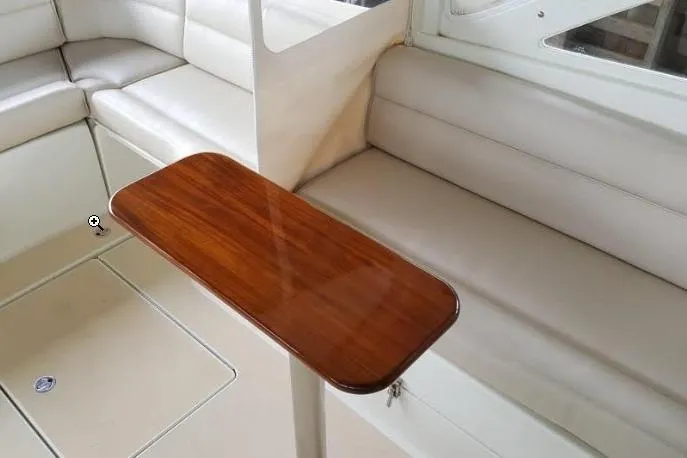True Love Yacht Photos Pics Interior of 2009 MJM 29z Express with sleek wooden table and cushioned seating.