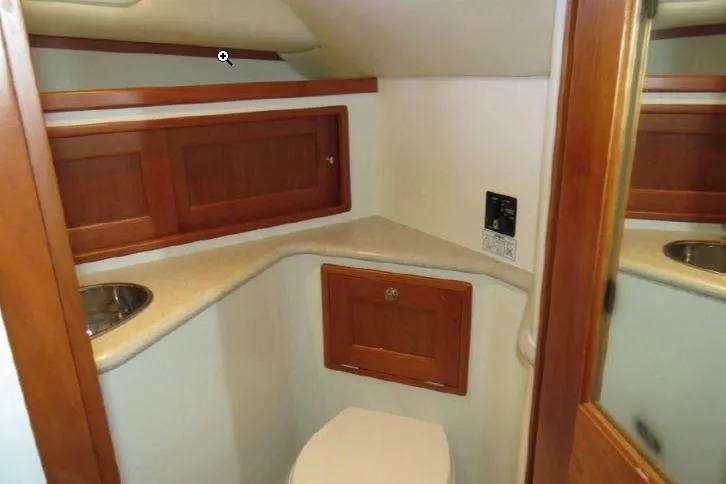 True Love Yacht Photos Pics 2009 MJM 29z Express boat interior bathroom with wooden cabinets and compact design.