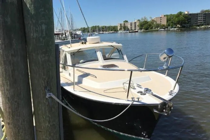 True Love Yacht Photos Pics 2009 MJM 29z Express boat docked in a marina, surrounded by calm water and buildings.