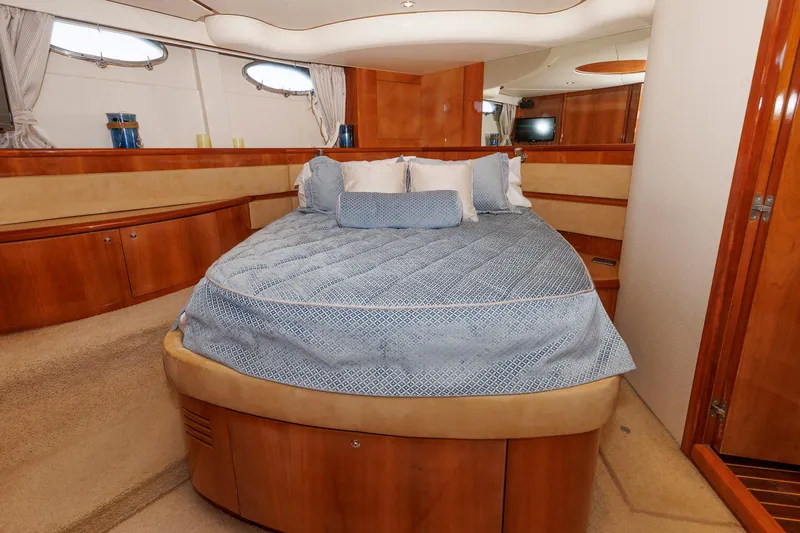 Tool N' Around Yacht Photos Pics Luxurious bedroom interior of 2005 Aicon Yachts 56 Flybridge with elegant wood finishes.