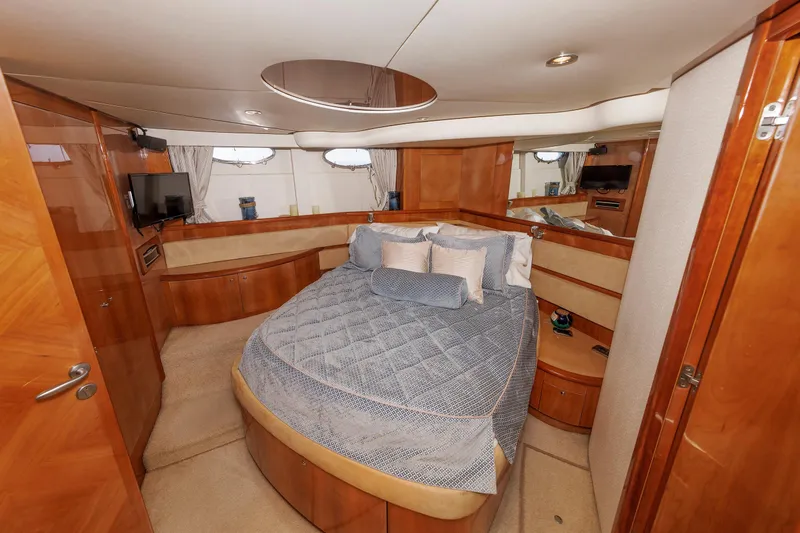 Tool N' Around Yacht Photos Pics Luxurious bedroom interior of 2005 Aicon Yachts 56 Flybridge with elegant wood finish.