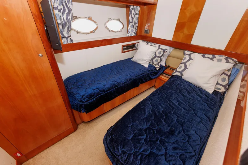 Tool N' Around Yacht Photos Pics Luxurious twin cabin in 2005 Aicon Yachts 56 Flybridge with blue bedding and wooden accents.