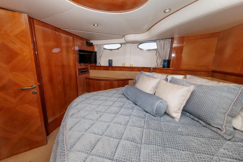Tool N' Around Yacht Photos Pics Luxurious bedroom interior of 2005 Aicon Yachts 56 Flybridge with elegant wood finishes.