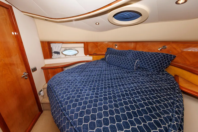 Tool N' Around Yacht Photos Pics Luxurious bedroom interior of 2005 Aicon Yachts 56 Flybridge with blue bedding.