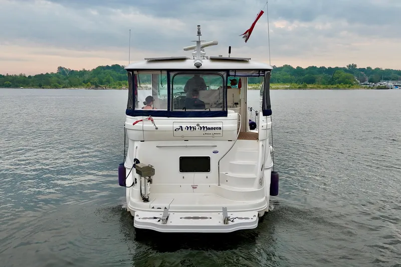 A Mi Manera Yacht Photos Pics 2007 Sea Ray 40 Motor Yacht on calm water, rear view with scenic background.