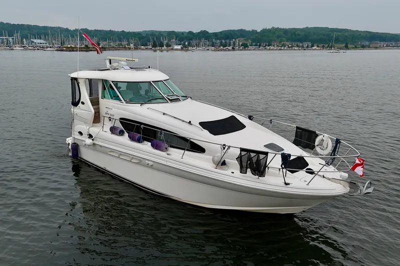 A Mi Manera Yacht Photos Pics 2007 Sea Ray 40 Motor Yacht on calm water, with marina in background.