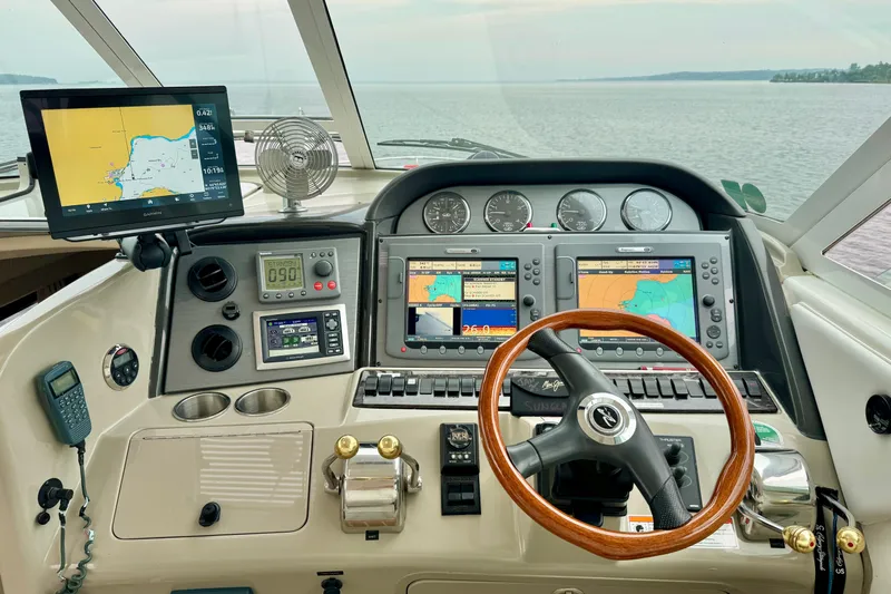 A Mi Manera Yacht Photos Pics 2007 Sea Ray 40 Motor Yacht helm with navigation screens and wooden steering wheel.