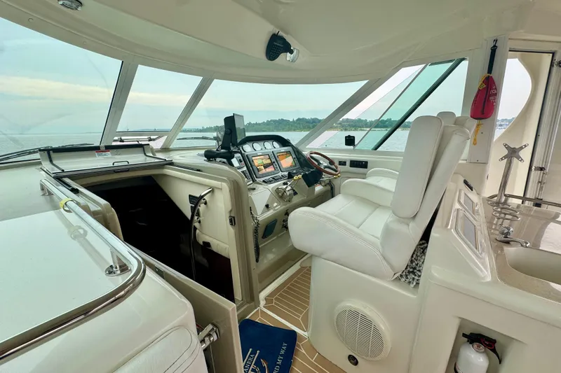 A Mi Manera Yacht Photos Pics Interior of 2007 Sea Ray 40 Motor Yacht cockpit with navigation equipment and white seating.