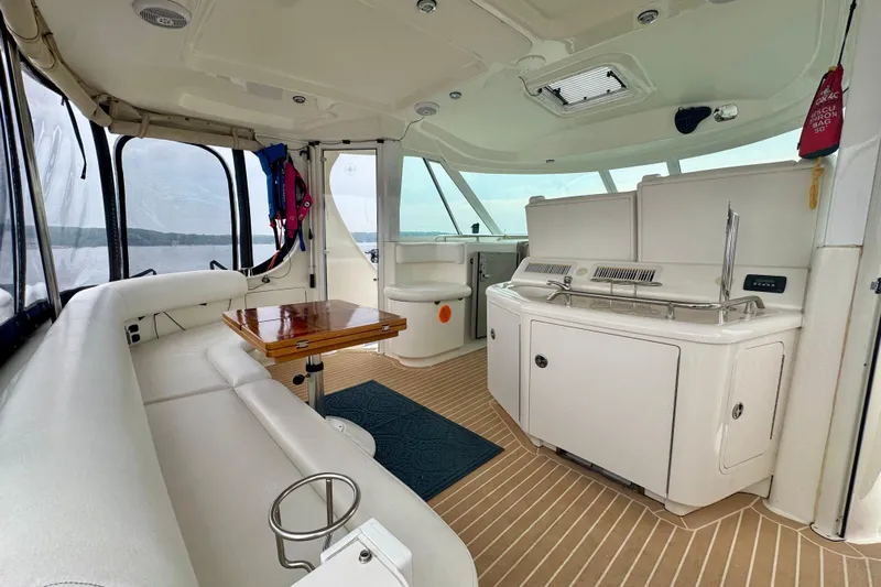 A Mi Manera Yacht Photos Pics Luxurious 2007 Sea Ray 40 Motor Yacht interior with white seating and wooden table.