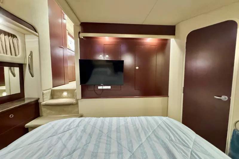 A Mi Manera Yacht Photos Pics Interior of 2007 Sea Ray 40 Motor Yacht bedroom with TV and wooden cabinetry.