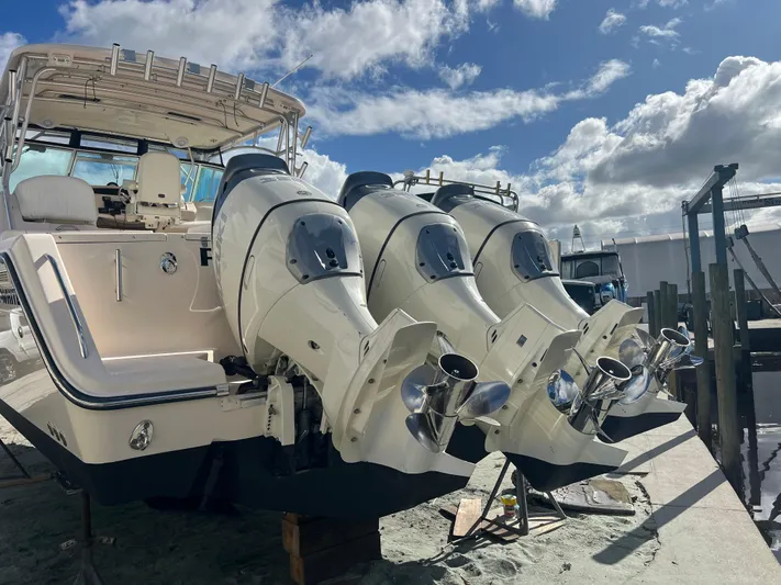  Yacht Photos Pics 2006 Grady-White 360 Express boat with triple outboard engines, docked under a cloudy sky.