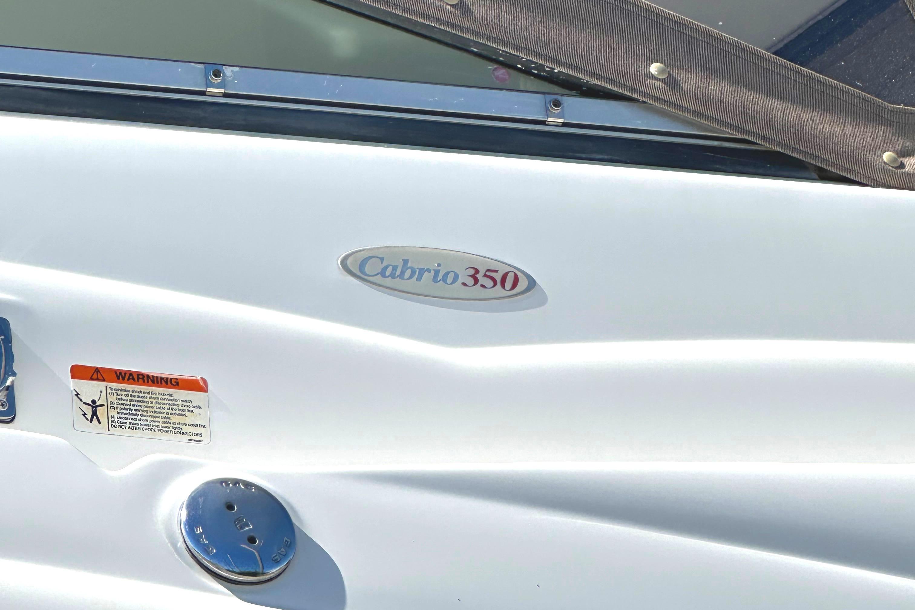 2006 Larson Cabrio 350 boat exterior with logo and warning label.