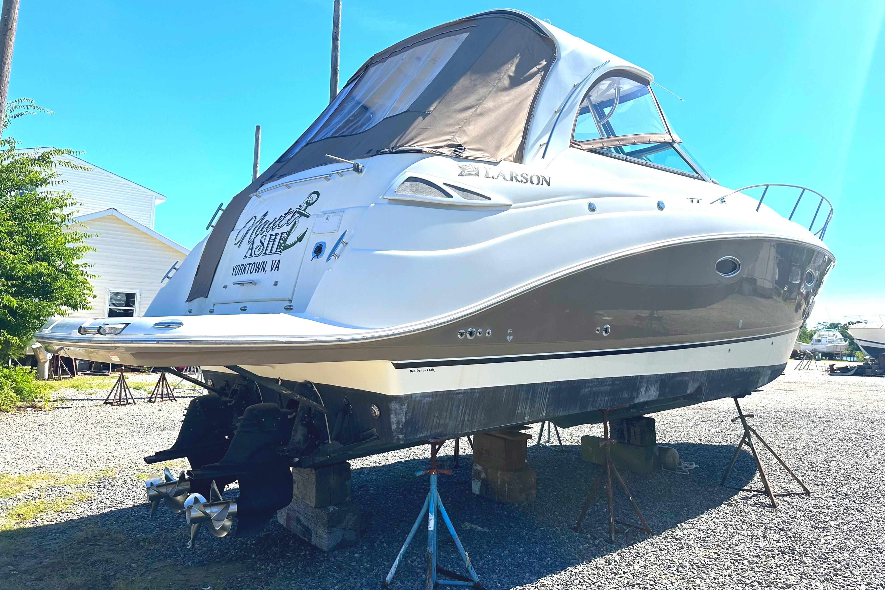 2006 Larson Cabrio 350 boat on stands, outdoor setting, clear sky.