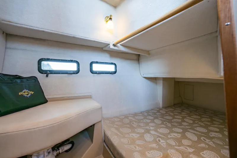 The Western Yacht Photos Pics 2014 Ranger Tugs R-31CB cabin interior with cozy bed and porthole windows.