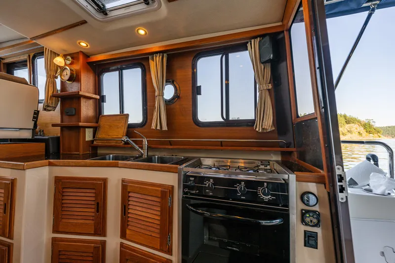 The Western Yacht Photos Pics 2014 Ranger Tugs R-31CB boat interior with wooden cabinetry and kitchen appliances.