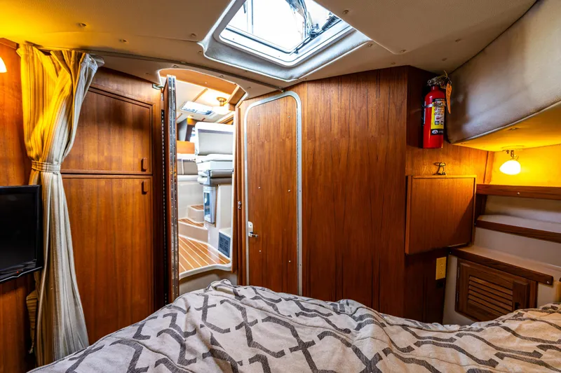 The Western Yacht Photos Pics Cozy interior of 2014 Ranger Tugs R-31CB boat with wood paneling and bedding.