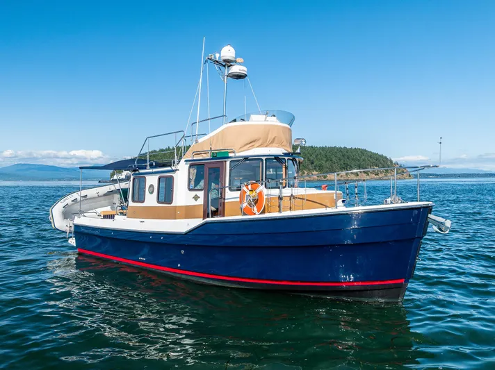 The Western Yacht Photos Pics 2014 Ranger Tugs R-31CB boat on calm water with clear blue sky.