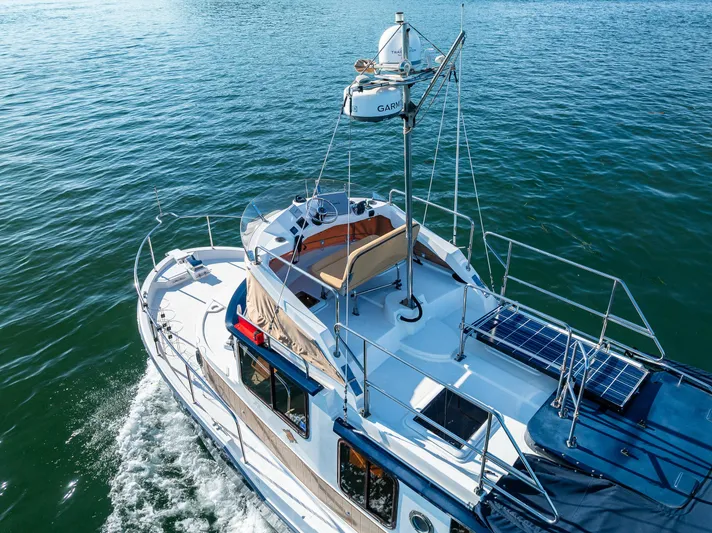The Western Yacht Photos Pics 2014 Ranger Tugs R-31CB cruising on open water, featuring solar panels and navigation equipment.