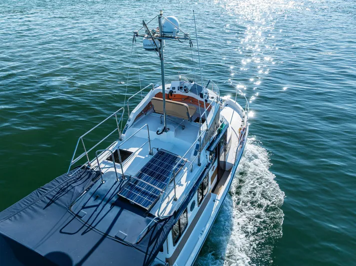 The Western Yacht Photos Pics 2014 Ranger Tugs R-31CB cruising on sparkling water, featuring solar panels and radar equipment.