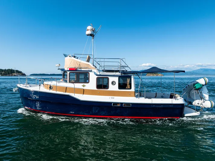 The Western Yacht Photos Pics 2014 Ranger Tugs R-31CB cruising on open water under clear blue skies.