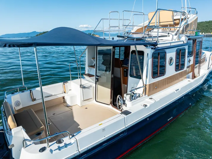 The Western Yacht Photos Pics 2014 Ranger Tugs R-31CB boat with canopy, docked on calm water.